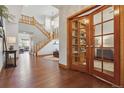 Spacious foyer featuring hardwood floors, staircase, and glass-paneled office doors at 4247 Thistlesage Ct, Castle Rock, CO 80109