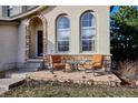 Inviting front porch with comfortable seating and stone accents, perfect for relaxing outdoors at 10293 Rustic Redwood Ct, Highlands Ranch, CO 80126
