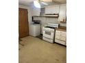 Kitchen with washer, gas range, and wood cabinets at 6500 W 14Th Ave, Lakewood, CO 80214