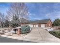 A spacious home featuring an attached four-car garage, brick exterior, and a long driveway at 14581 E Oberlin Pl, Aurora, CO 80014