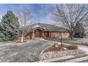 Charming brick home featuring a stone pathway, mature trees, and a classic front facade at 14581 E Oberlin Pl, Aurora, CO 80014