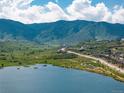 Scenic view of a lake and surrounding community, featuring mountains in the background and a walking path alongside the water at 5225 Mesa Top Dr, Monument, CO 80132