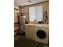 Basement laundry area with washer, dryer and water heater at 571 Geneva St, Aurora, CO 80010