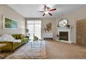 Inviting living room with a cozy fireplace, ceiling fan, and glass sliding doors at 3852 S Dallas St # 8-102, Aurora, CO 80014