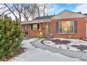 Charming brick home with a curved walkway and some snow on the ground at 2531 Niagara St, Denver, CO 80207