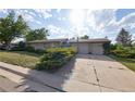 Classic brick home featuring a spacious driveway and attached three-car garage at 6579 S Lincoln St, Centennial, CO 80121