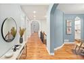 Hallway with archways, hardwood floors, neutral paint and staircase to the left at 9715 E 33Rd Ave, Denver, CO 80238