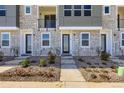 Townhome front entrance with stone facade, landscaped with decorative plants and gravel at 20588 E 63Rd Ave, Aurora, CO 80019