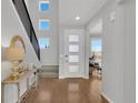 Bright foyer with hardwood floors, a modern white door and staircase with contemporary black railings at 2602 Meadows Blvd # A, Castle Rock, CO 80109