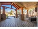 Spacious covered porch with wooden beams, stone pillars and comfortable outdoor seating at 1970 Woodbourne Ter, Castle Rock, CO 80104