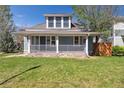 Inviting two-story home featuring a charming front porch and well-manicured lawn at 5101 Meade St, Denver, CO 80221