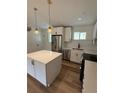 Modern kitchen featuring stainless steel appliances, white cabinets, and a center island at 5535 Clear Creek Dr, Denver, CO 80212