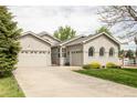Attractive home featuring a well-manicured lawn, attached garage and long driveway at 1510 S De Gaulle Cir, Aurora, CO 80018