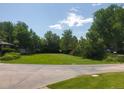 Well-maintained front yard featuring a green lawn and mature trees, enhancing curb appeal at 2208 Champlain Dr, Boulder, CO 80301