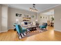 Well-lit living room with a modern rug, stylish seating, and an inviting dining area at 4961 Aspen Creek Dr, Broomfield, CO 80023