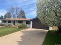 Single story house featuring a brown roof, brown two car garage door, and mature tree at 5886 S Logan St, Centennial, CO 80121