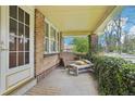 Relaxing front porch with a comfortable seating area and verdant vines creating a cozy outdoor space at 925 S University Blvd, Denver, CO 80209