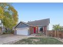 Gray and brick ranch home with a two-car garage and red front door at 7814 Club Crest Dr, Arvada, CO 80005