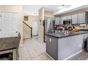 Open kitchen layout with gray cabinets, stainless steel appliances, and access to the staircase at 2143 Coronado N Pkwy # C, Denver, CO 80229