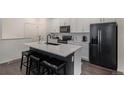 Modern kitchen featuring stainless steel appliances, a large center island, and sleek white cabinets at 6027 N Netherland Ct, Aurora, CO 80019