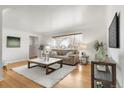 Sunlit living room with hardwood floors, neutral furniture, and stylish decor at 479 S Kendall St, Lakewood, CO 80226