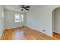 Bright living room with hardwood floors, a ceiling fan, and arched entry to the kitchen at 4078 Ames St, Wheat Ridge, CO 80212