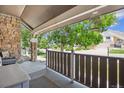 Inviting covered front porch with stone accents and wooden railing at 1744 Brookside Dr, Highlands Ranch, CO 80126