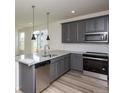 Modern kitchen boasts granite countertops, stainless steel appliances, and gray cabinets, perfect for culinary enthusiasts at 1178 Hargreaves Way, Erie, CO 80516