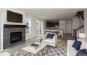 Bright open living room with fireplace, modern furnishings, and seamless flow to dining area and kitchen at 1178 Hargreaves Way, Erie, CO 80516