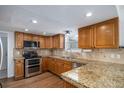 Well-equipped kitchen with stainless steel appliances, granite countertops, and wood cabinets at 510 W Prestwick Way, Castle Rock, CO 80104