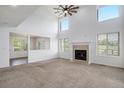 Bright living room with neutral carpet, fireplace, and tall windows showcasing the outdoor view at 510 W Prestwick Way, Castle Rock, CO 80104