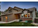 Well-kept home with a combination of brick and siding, complemented by lush green grass and professional landscaping at 12534 W Hoover Ave, Littleton, CO 80127
