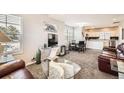 Bright open-concept living room featuring plush carpet, a comfortable seating area, and plenty of natural light at 202 Ash St, Bennett, CO 80102