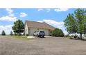Exterior shot of a home with a circular driveway and attached garages at 34771 E 153Rd Ct, Hudson, CO 80642