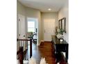 Bright hallway with hardwood floors, a console table, and views into adjacent rooms at 6945 Fargo Trl, Littleton, CO 80125