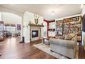 Cozy living room with a fireplace, wood floors, and a large bookshelf at 18984 W 85Th Blf, Arvada, CO 80007