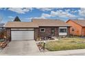 Inviting brick home featuring a well-manicured lawn and an attached two-car garage at 412 N 10Th Ave, Brighton, CO 80601