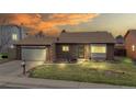 Charming brick home with well-maintained lawn and attached two-car garage at dusk at 412 N 10Th Ave, Brighton, CO 80601