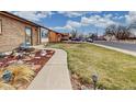 Landscaped front yard with walkway leading to the home, showcasing the colorful and mature landscaping at 412 N 10Th Ave, Brighton, CO 80601