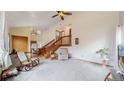 Bright living room with vaulted ceilings, a cozy rocking chair, adjacent to an open staircase and the kitchen at 412 N 10Th Ave, Brighton, CO 80601