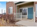 Charming condo entrance with a teal door, brick accents, and low-maintenance landscaping at 2662 S Cathay Way # 110, Aurora, CO 80013