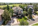 Inviting two-story home with stone accents, front porch, and mature trees surrounding a golf course at 7120 Forest Ridge Cir, Castle Pines, CO 80108
