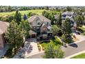 Picturesque two-story home with a two-car garage, mature trees, and a well-kept lawn at 7120 Forest Ridge Cir, Castle Pines, CO 80108