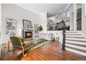 Bright living room with hardwood floors, a fireplace, and an elegant staircase with iron railings at 7120 Forest Ridge Cir, Castle Pines, CO 80108