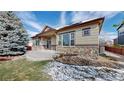 Backyard patio features stone accents, a concrete patio, and mature landscaping at 6544 S Millbrook Way, Aurora, CO 80016