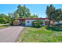Charming single-story home with a spacious driveway and well-maintained lawn, perfect for a Gathering at 1560 Simms St, Lakewood, CO 80215