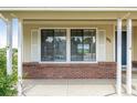 View of the front window with brick siding and white shutters at 551 Snowy Owl Pl, Highlands Ranch, CO 80126