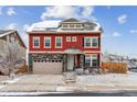 Charming two-story home with red siding, stone accents, and a well-maintained front yard in winter at 23593 E Chenango Pl, Aurora, CO 80016