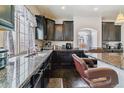 Bright kitchen with granite countertops, sleek cabinetry, stainless steel appliances, and stylish breakfast bar at 23593 E Chenango Pl, Aurora, CO 80016