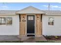 Home exterior featuring a black front door, new wood trim, and manicured landscaping at 1130 Orchard St, Golden, CO 80401